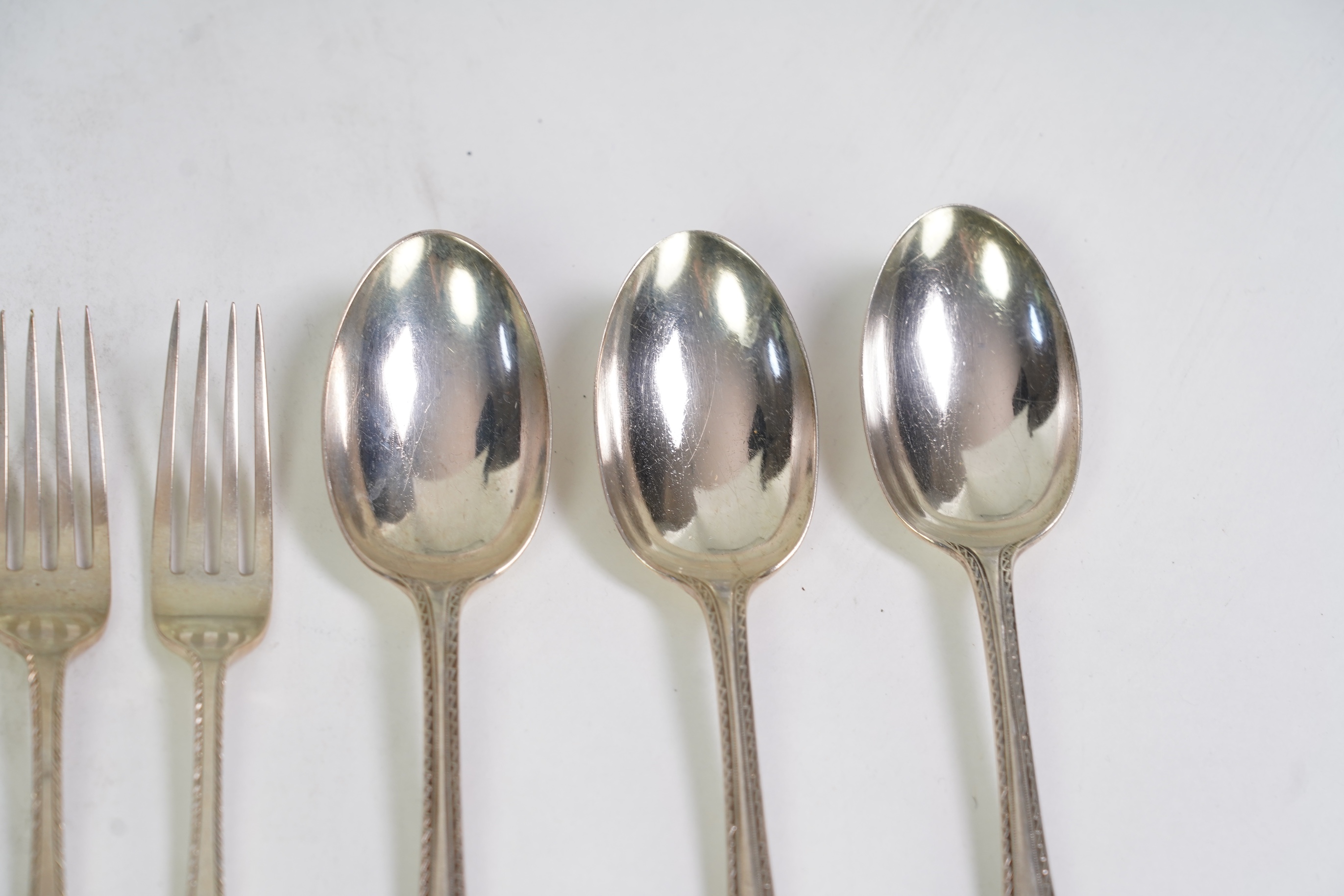 A set of six George V fancy Old English pattern table spoons by Elkington & Co, Birmingham, 1919, 22.2cm, together with a set of six fancy Hanoverian pattern table forks, Goldsmiths & Silversmiths Co Ltd, London, 1918, 3